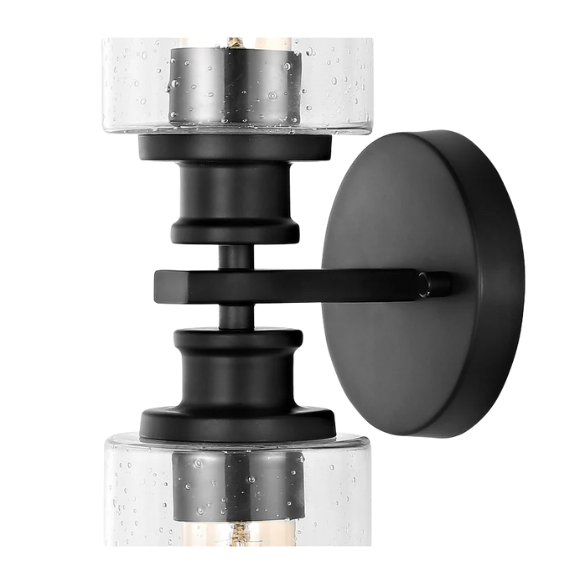 Art Deco-style black wall sconce with dual clear seeded glass cylinder shades and Edison-style LED bulbs, suitable for bathroom or hallway lighting

