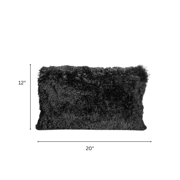 Set of two black faux fur throw pillows with white-tipped shaggy texture on a modern neutral-toned sofa

