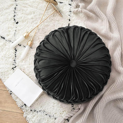 Black velvet round throw pillows with hand-sewn pleats and central button, set of two 14.5-inch plush decorative cushions styled on a modern neutral sofa.

