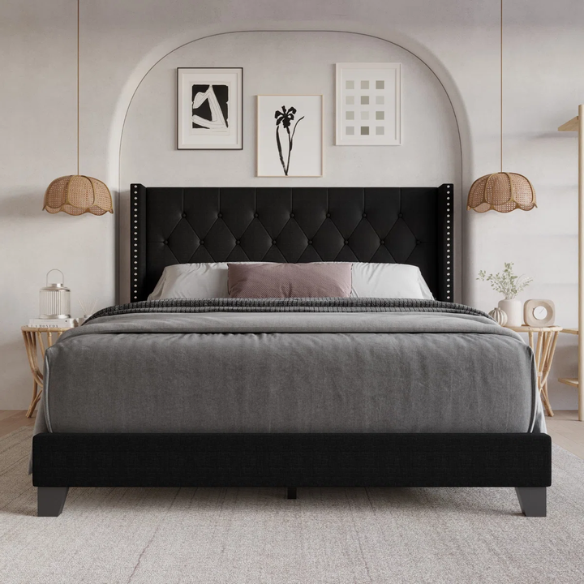 Black upholstered full-size bed with tufted wingback headboard and nailhead trim