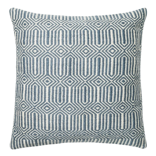 Blue and cream geometric throw pillow on a modern outdoor chair in a patio setting

