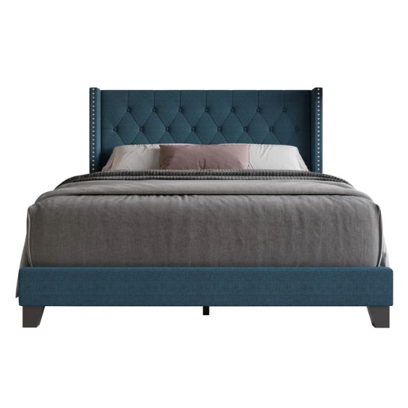 Blue upholstered full-size bed with tufted wingback headboard and nailhead trim