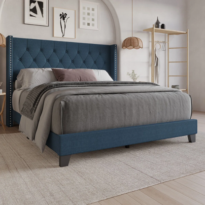 Blue upholstered full-size bed with tufted wingback headboard and nailhead trim