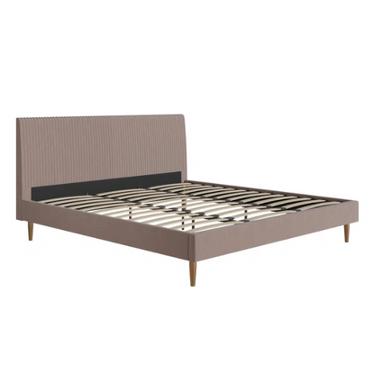 Blush pink velvet upholstered king-size platform bed with padded rectangular headboard, solid wood slats, and elegant low-profile frame.

