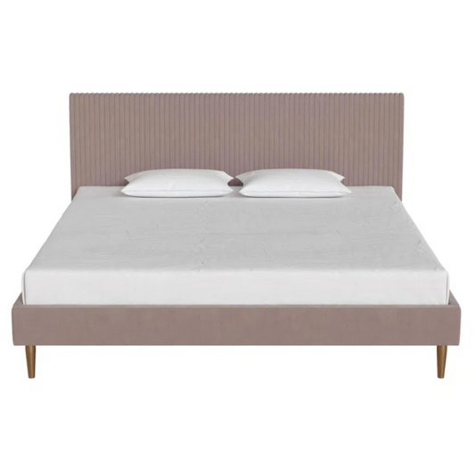Blush pink velvet upholstered king-size platform bed with padded rectangular headboard, solid wood slats, and elegant low-profile frame.

