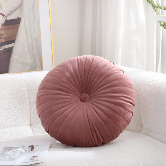 Blush velvet round throw pillow with button closure and pleated design, soft cotton fill for added comfort and support, perfect for home décor and sofa.