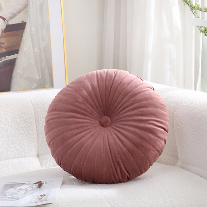 Blush velvet round throw pillow with button closure and pleated design, soft cotton fill for added comfort and support, perfect for home décor and sofa.