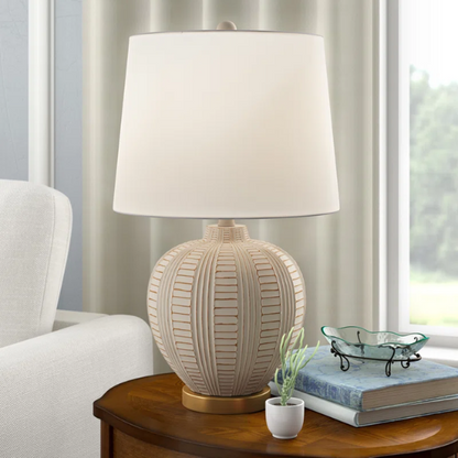 Cream and rose gold resin table lamp with carved textured base, white cotton drum shade, and built-in USB charging port for modern boho interiors

