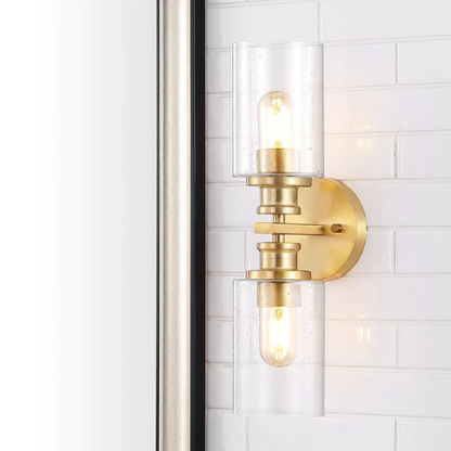 Rich brass wall sconce with dual clear seeded glass cylinder shades and Edison-style LED bulbs, perfect for upscale bathroom or hallway lighting

