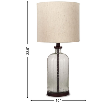Bronze-tone seeded glass table lamp with beige fabric drum shade, featuring a metal base and compact design for modern farmhouse or industrial interiors

