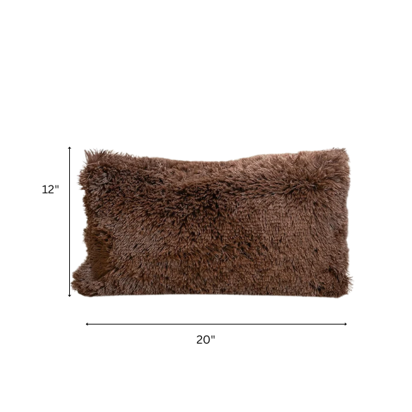 Set of two brown faux fur throw pillows with plush shaggy texture on a rustic wood-accented couch


