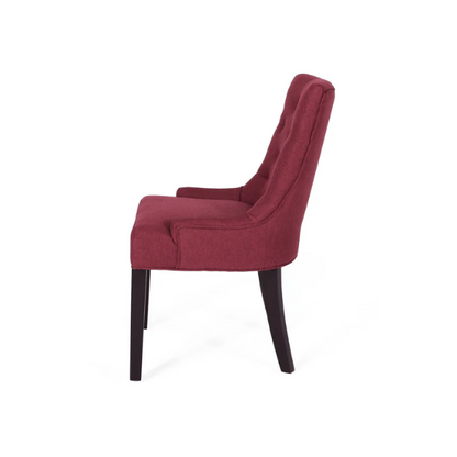 Set of four burgundy upholstered dining chairs featuring diamond tufted backs, armless design, sloped arms, and espresso brown wooden legs.

