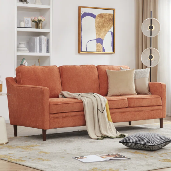 Burnt orange chenille upholstered sofa with curved track arms, brown tapered wooden legs, and plush foam cushions in a modern mid-century design.