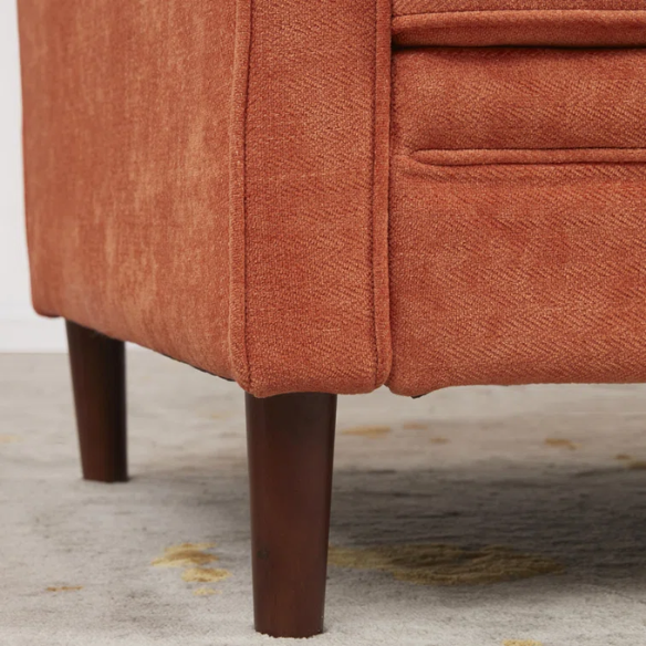 Burnt orange chenille upholstered sofa with curved track arms, brown tapered wooden legs, and plush foam cushions in a modern mid-century design.