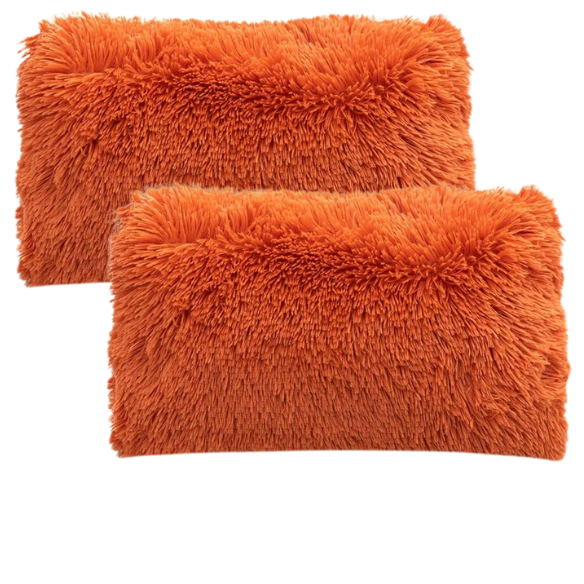 Set of two burnt orange faux fur throw pillows with shaggy texture on a modern sofa

