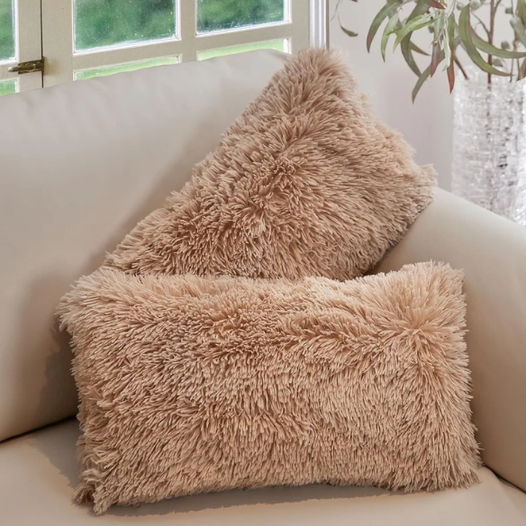 Set of two camel faux fur throw pillows with plush texture on a modern sofa

