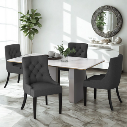 Set of four dark charcoal grey upholstered dining chairs featuring diamond tufted backs, armless design, sloped sides, and espresso wood legs.

