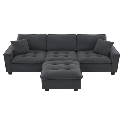 Charcoal grey suede L-shaped sectional sofa with tufted cushions, reversible chaise, removable ottoman, and two matching throw pillows