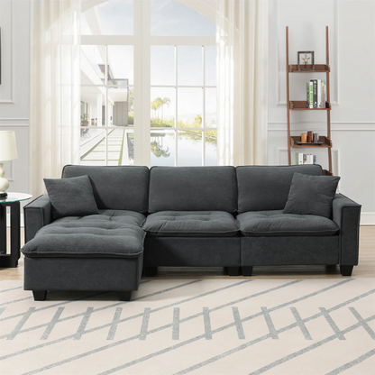 Charcoal grey suede L-shaped sectional sofa with tufted cushions, reversible chaise, removable ottoman, and two matching throw pillows
