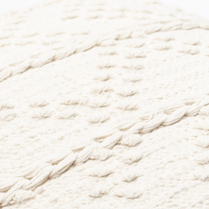 Cream handwoven boho throw pillow with chevron texture on a modern neutral-toned sofa

