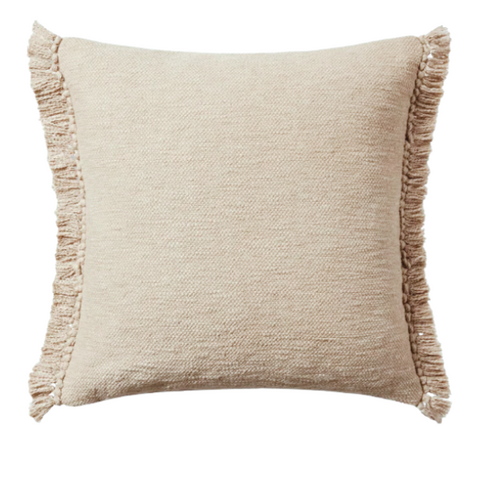 Cream cotton blend throw pillow with fringe, 22x22 square cushion, styled on a modern sofa for soft, neutral home decor.

