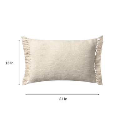 Cream lumbar throw pillow with soft fringe trim, rectangular 13x21 design, made from neutral cotton blend fabric, styled on a sofa for cozy, modern home decor.

