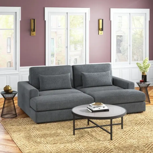 Dark grey corduroy convertible sleeper sofa with adjustable headrest, twin bed functionality, and mid-century modern wood legs