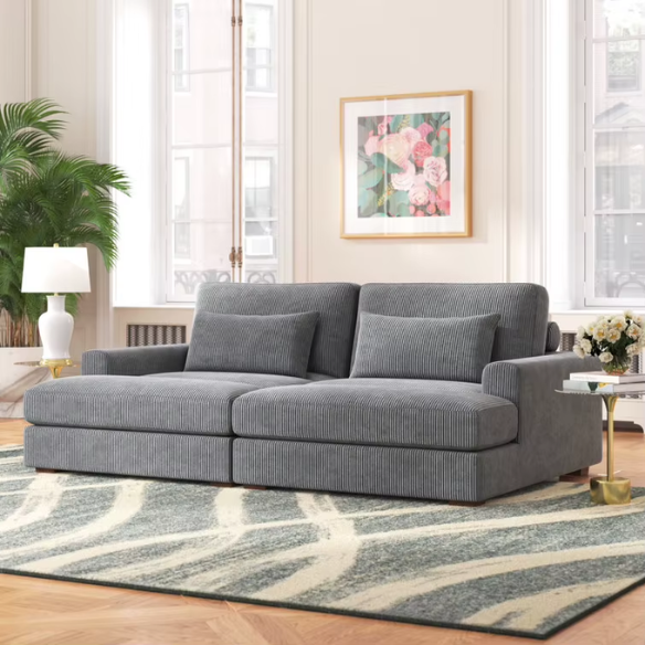 Dark grey corduroy convertible sleeper sofa with adjustable headrest, twin bed functionality, and mid-century modern wood legs