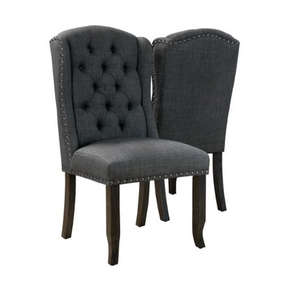 Set of two dark grey wingback farmhouse dining chairs with tufted backs, brass nailhead trim, and espresso-finished wooden legs

