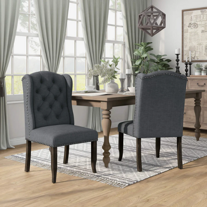 Set of two dark grey wingback farmhouse dining chairs with tufted backs, brass nailhead trim, and espresso-finished wooden legs

