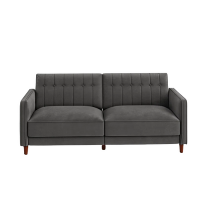Dark grey velvet convertible sofa with vertical tufting, split-back design, square arms, and brown tapered legs, convertible into a twin-size sleeper.