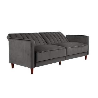 Dark grey velvet convertible sofa with vertical tufting, split-back design, square arms, and brown tapered legs, convertible into a twin-size sleeper.