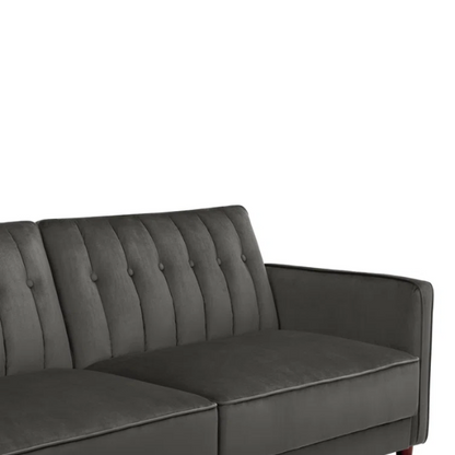 Dark grey velvet convertible sofa with vertical tufting, split-back design, square arms, and brown tapered legs, convertible into a twin-size sleeper.