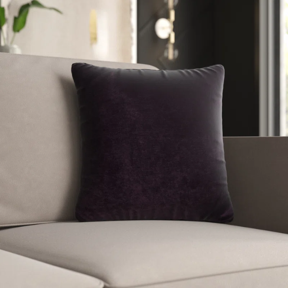 Dark purple crushed velvet throw pillow, 16x16 square design with soft texture and reversible fabric, styled on a modern sofa for cozy, luxurious home decor.

