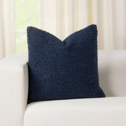Deep navy blue bouclé throw pillow with looped texture, square accent pillow on a modern sofa

