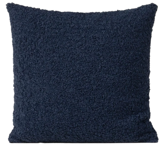 Deep navy blue bouclé throw pillow with looped texture, square accent pillow on a modern sofa

