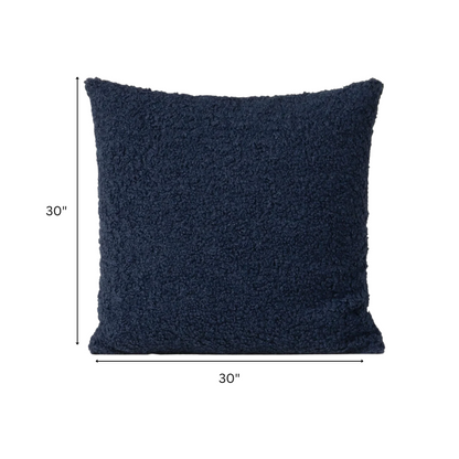 Deep navy blue bouclé throw pillow with looped texture, square accent pillow on a modern sofa


