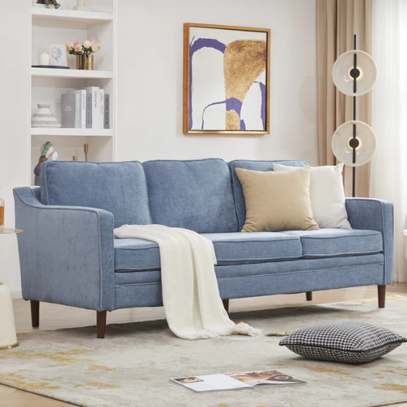 Dusty blue chenille upholstered sofa featuring curved track arms, tapered wooden legs, and foam-filled cushions in a mid-century modern design.