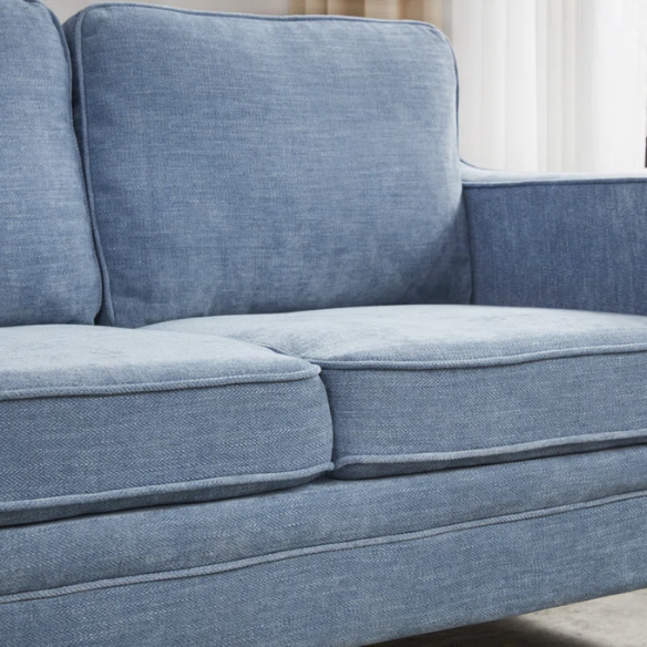 Dusty blue chenille upholstered sofa featuring curved track arms, tapered wooden legs, and foam-filled cushions in a mid-century modern design.