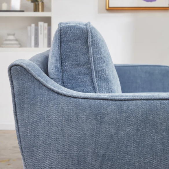 Dusty blue chenille upholstered sofa featuring curved track arms, tapered wooden legs, and foam-filled cushions in a mid-century modern design.