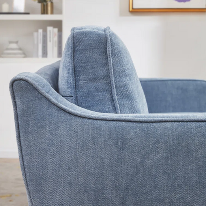 Dusty blue chenille upholstered sofa featuring curved track arms, tapered wooden legs, and foam-filled cushions in a mid-century modern design.