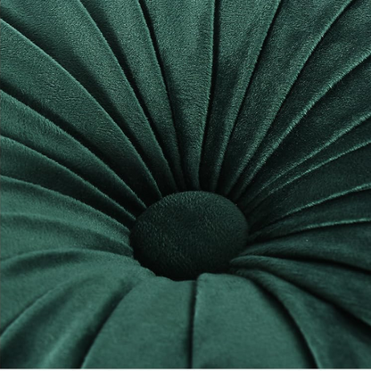 Emerald green velvet round throw pillows with hand-pleated detail and central button, 14.5-inch set of two on a white sofa in a stylish living room.

