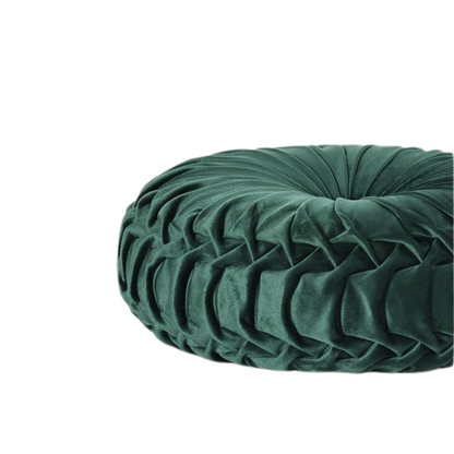 Emerald green velvet round throw pillows with hand-pleated detail and central button, 14.5-inch set of two on a white sofa in a stylish living room.

