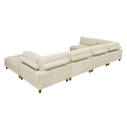 Beige modular sectional sofa with corduroy upholstery, removable cushions, and matching ottoman – seats six in a modern L-shaped or U-shaped layout with solid wood legs.


