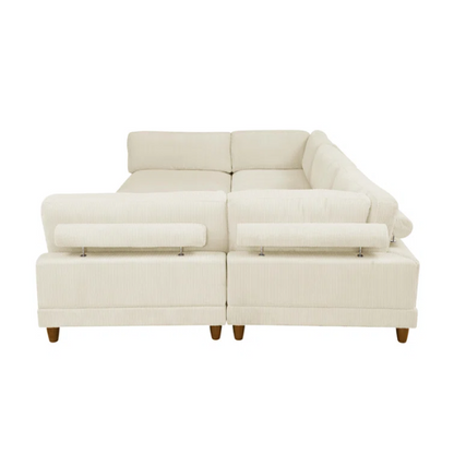 Beige modular sectional sofa with corduroy upholstery, removable cushions, and matching ottoman – seats six in a modern L-shaped or U-shaped layout with solid wood legs.

