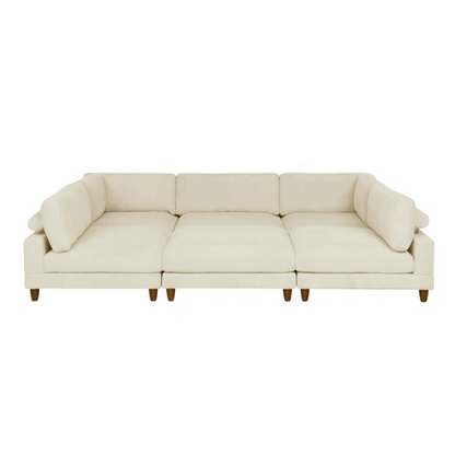 Beige modular sectional sofa with corduroy upholstery, removable cushions, and matching ottoman – seats six in a modern L-shaped or U-shaped layout with solid wood legs.

