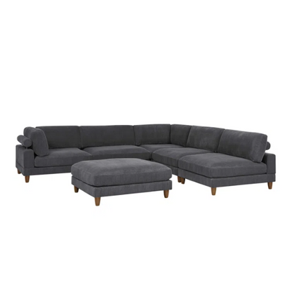 Dark grey modular sectional sofa with soft corduroy upholstery, matching ottoman, and removable cushions — seats six with flexible L- or U-shaped configurations.


