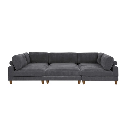Dark grey modular sectional sofa with soft corduroy upholstery, matching ottoman, and removable cushions — seats six with flexible L- or U-shaped configurations.

