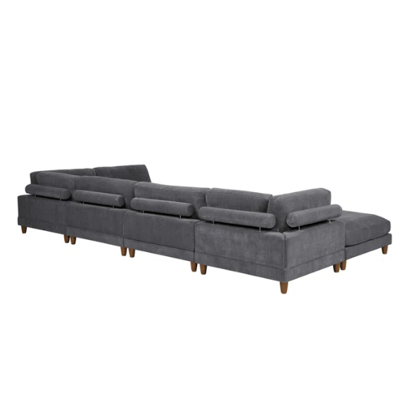 Dark grey modular sectional sofa with soft corduroy upholstery, matching ottoman, and removable cushions — seats six with flexible L- or U-shaped configurations.

