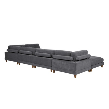 Dark grey modular sectional sofa with soft corduroy upholstery, matching ottoman, and removable cushions — seats six with flexible L- or U-shaped configurations.


